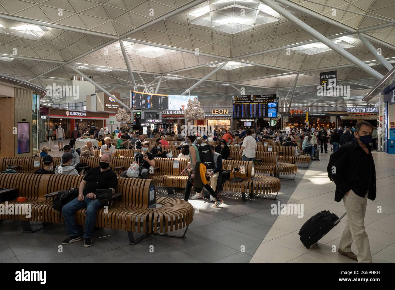 18 agosto 2021, Londra, Regno Unito. Un numero moderato di viaggiatori è visto passare attraverso le partenze all'aeroporto di Londra Stansted. Se da un lato lo status di doppia vaccinazione e il ‘Passo del Covid del NHS’ hanno reso i viaggi più semplici per alcuni, dall’altro c’è una forte frustrazione per quanto riguarda i costi e l’inefficienza dei test PCR privati obbligatori prima del volo. Londra, UK Credit: Joshua Windsor/Alamy Live News Foto Stock
