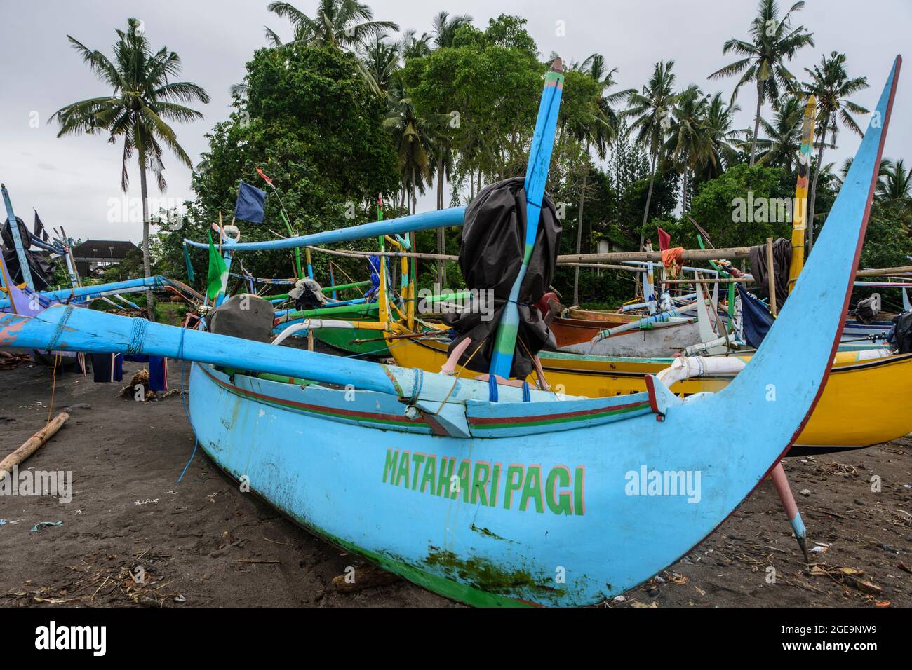 Outrigger barche da pesca (Jukungs) ormeggiate sulla spiaggia vicino Pemuteran, costa nord-occidentale di Bali, Indonesia. Foto Stock