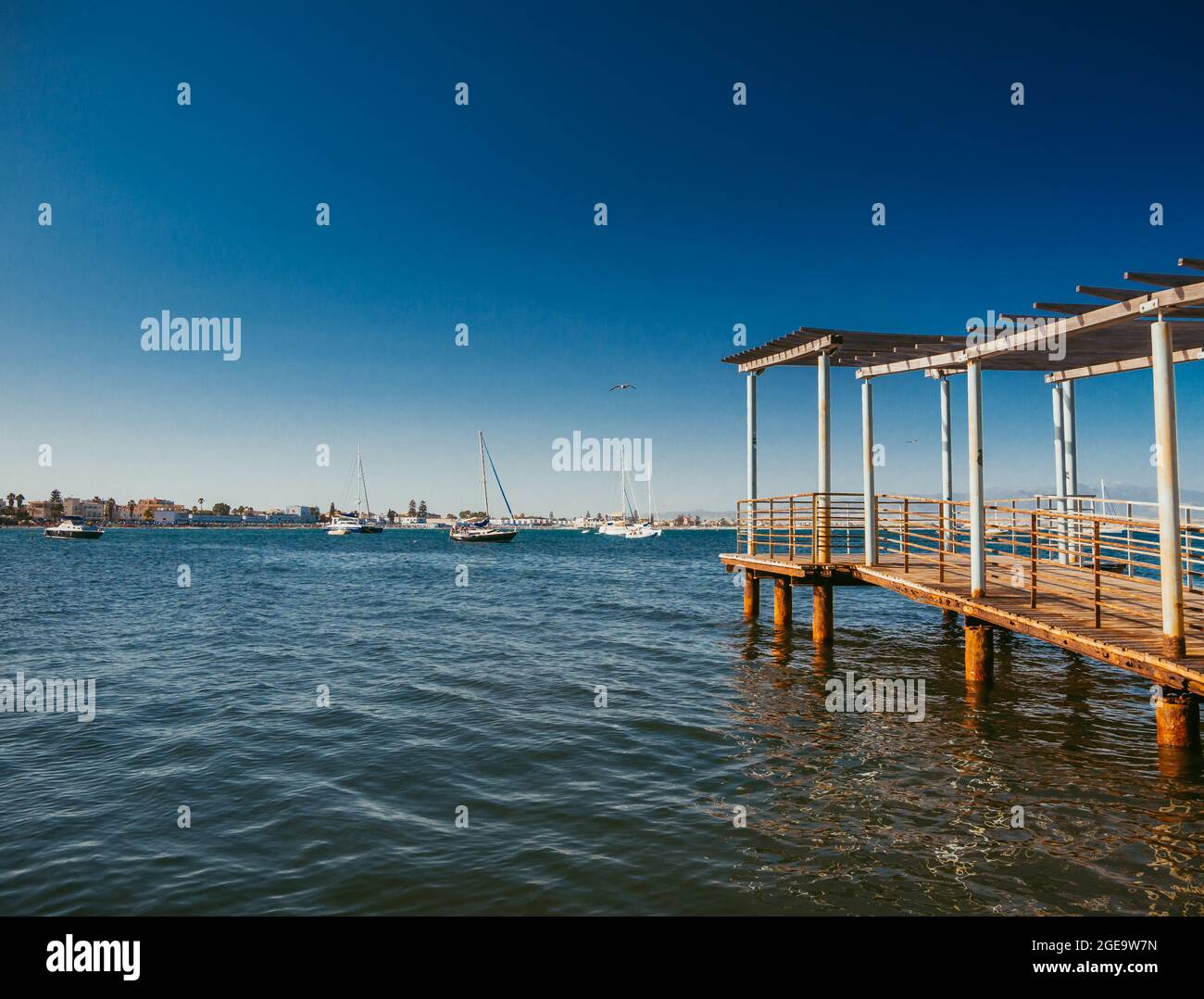 lungo molo di legno sul mare verso l'orizzonte Foto Stock