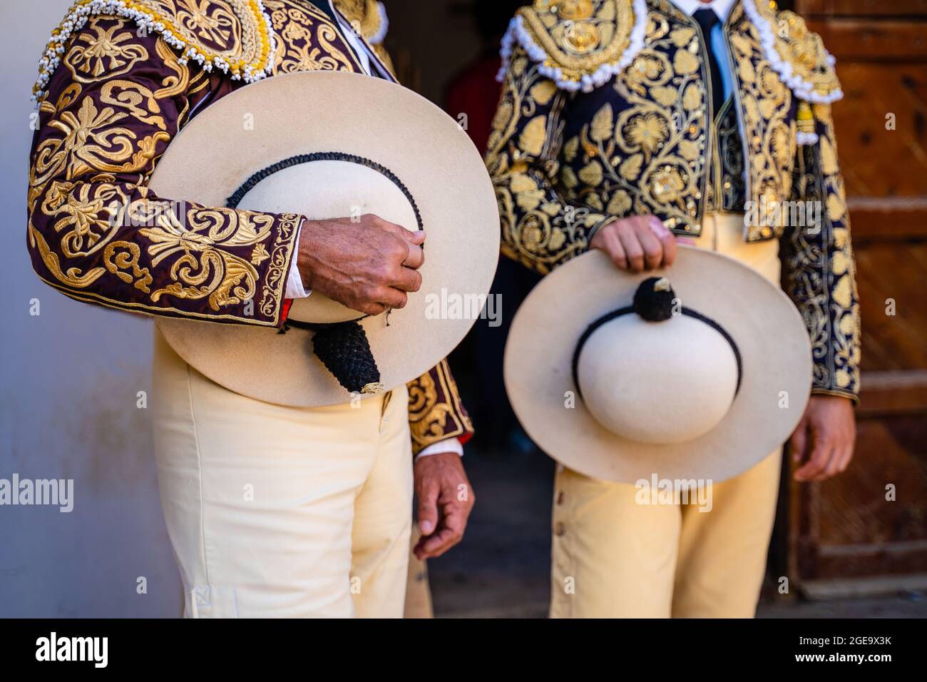 Coltivare i bullfighter irriconoscibili in costume tradizionale decorato con ricami che tengono cappelli e si prepara per la festa della corrida Foto Stock