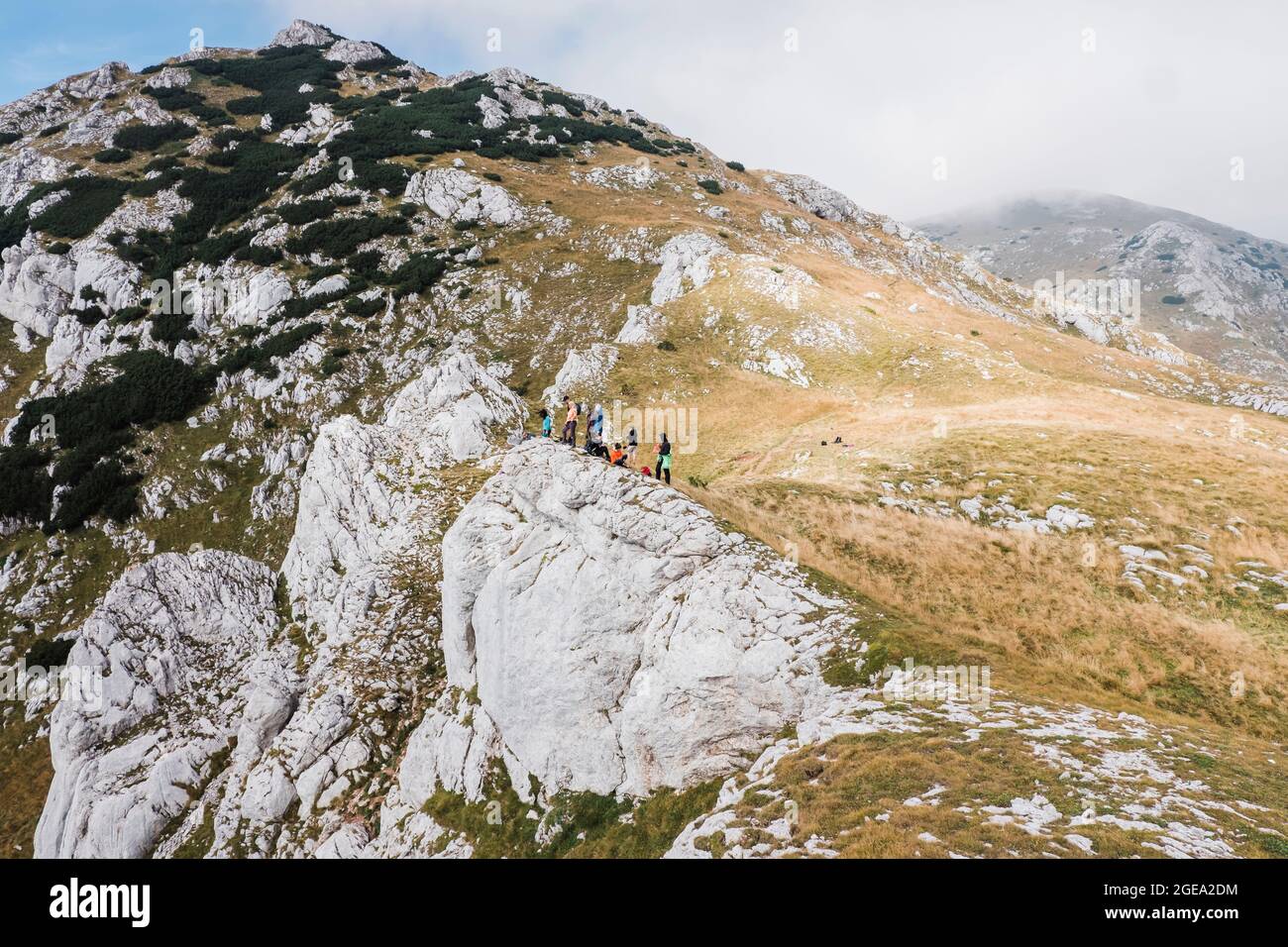 Un gruppo di escursionisti che riposano sulla cima di una montagna. Foto Stock