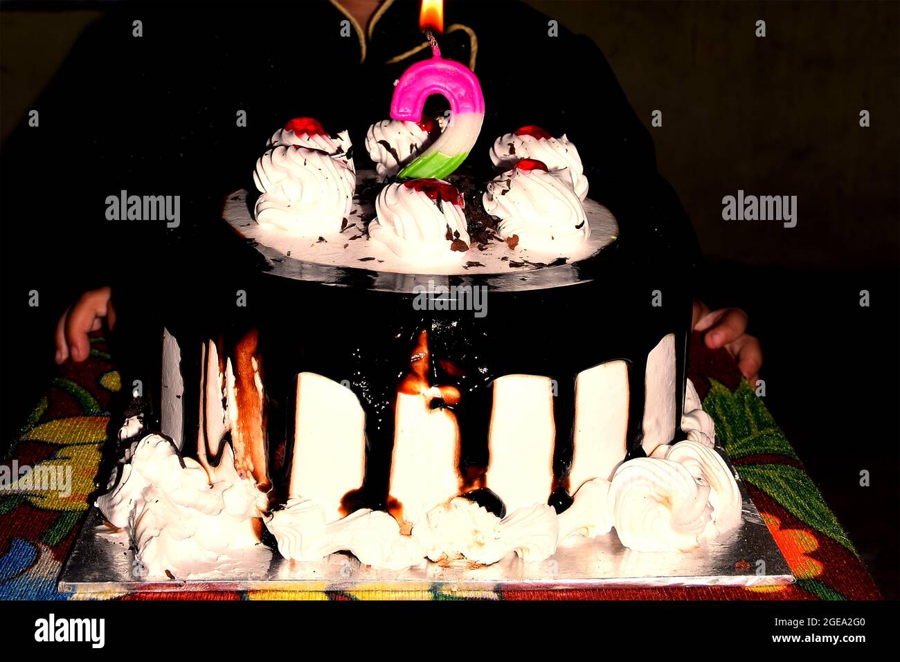 Birthday Drip Cake e candela bruciante con cioccolato e spruzzi banner nero isolato di sfondo con decorazione festa. Concetto di celebrazione. Drip. Alla moda Foto Stock
