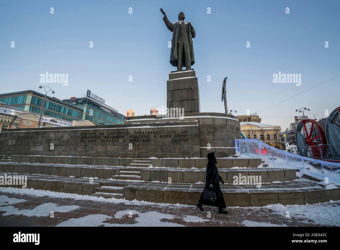 Una donna russa passa sotto una statua di Lenin a Ekaterinburg in Russia. Foto Stock