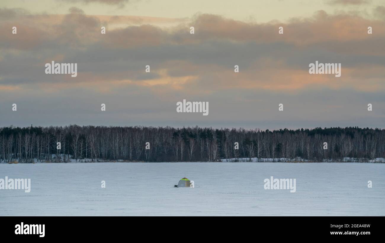 Tenda di pescatori di ghiaccio su un lago ghiacciato nella regione delle montagne Ural in Russia Foto Stock
