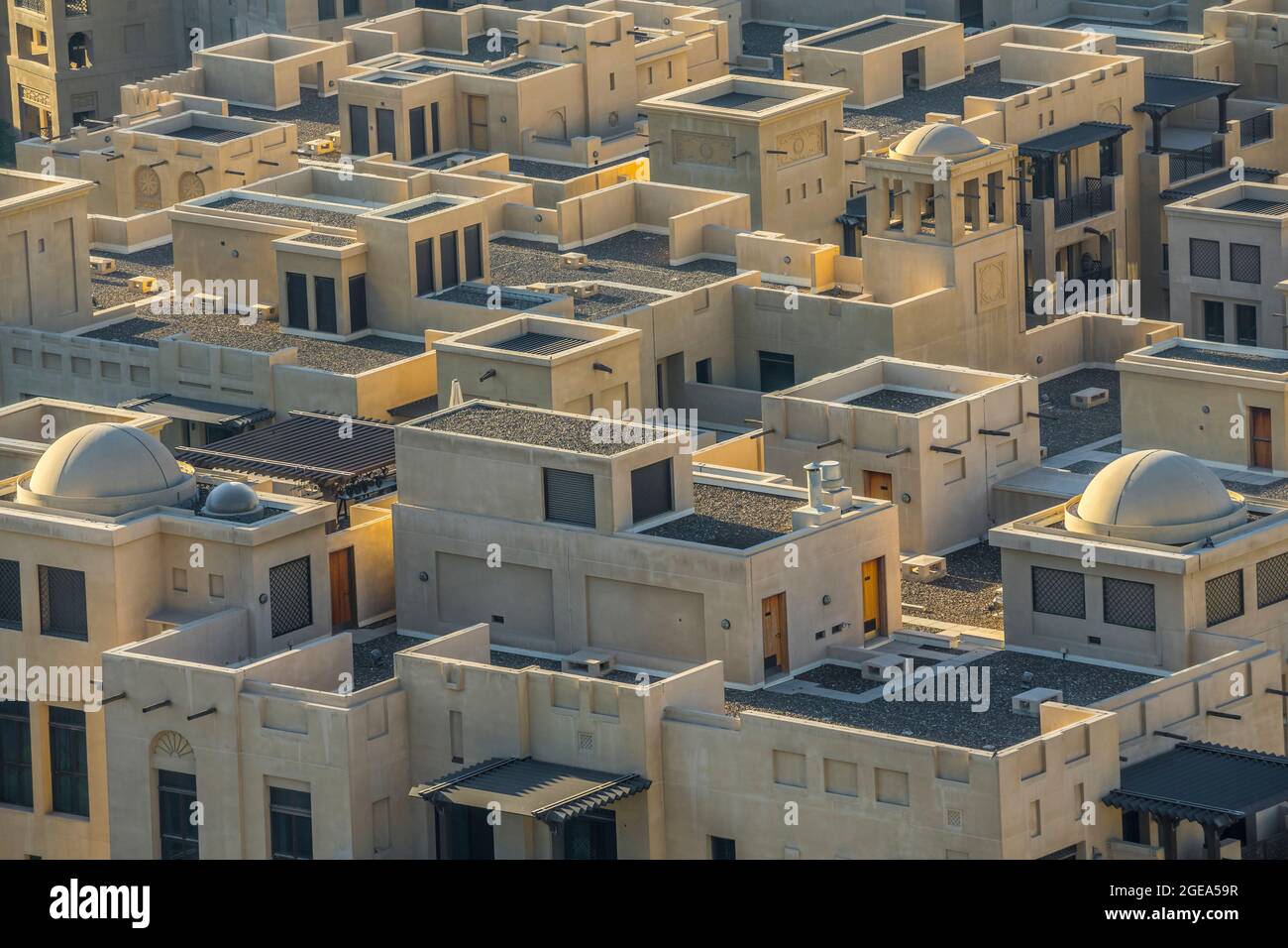 Eleganti case in stile adobe sotto lo sguardo torreggiante del vicino Burj Khalifa a Dubai. Foto Stock