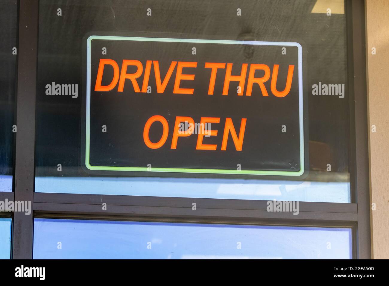 il cartello rosso indica drive thru aperto nella finestra del ristorante Foto Stock