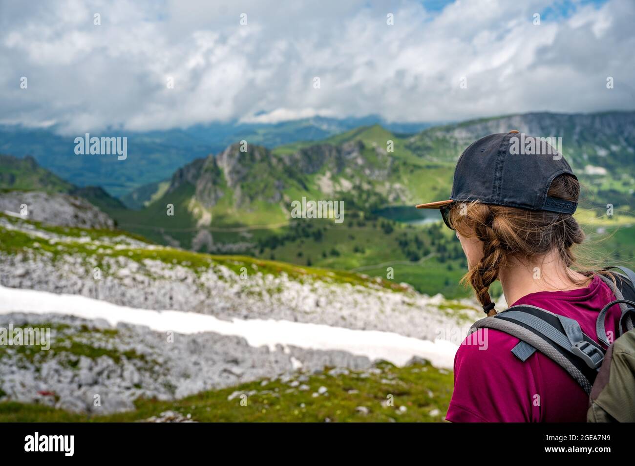 Ragazza escursionistica con berretto godendo di una vista epica di Diemtigtal con Seebergsee nelle Alpi bernesi Foto Stock