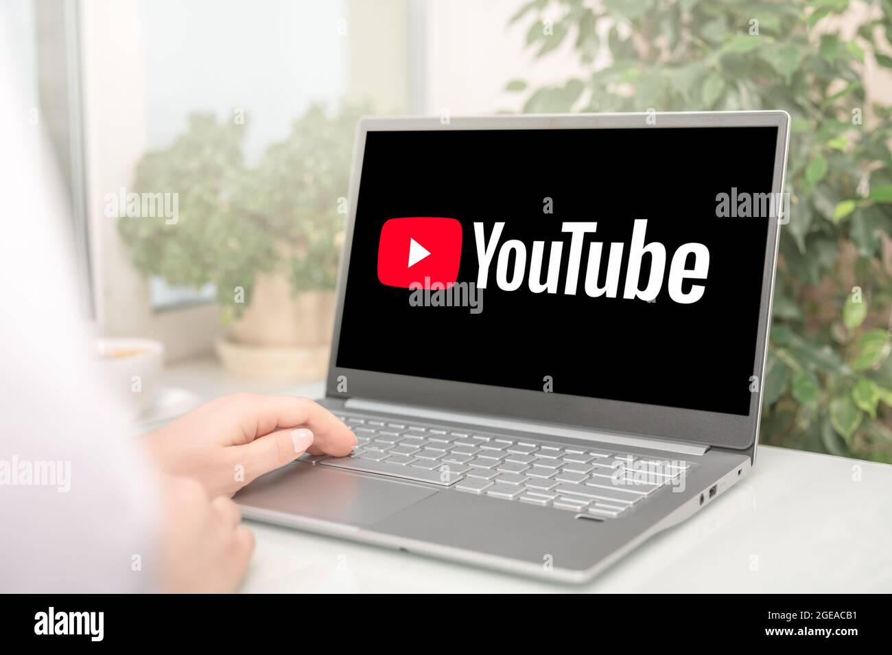 Mosca, Russia - 17 agosto 2021 : Donna che usa un computer portatile per connettersi alla home page del sito web di YouTube. YouTube è un sito Web per la condivisione di video. YouTube sullo schermo l Foto Stock