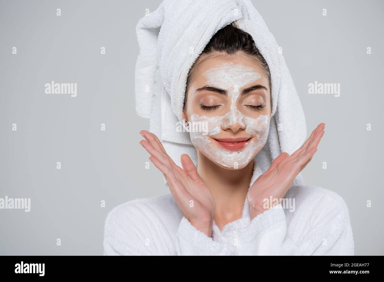 felice giovane donna con scrub viso isolato su grigio Foto Stock