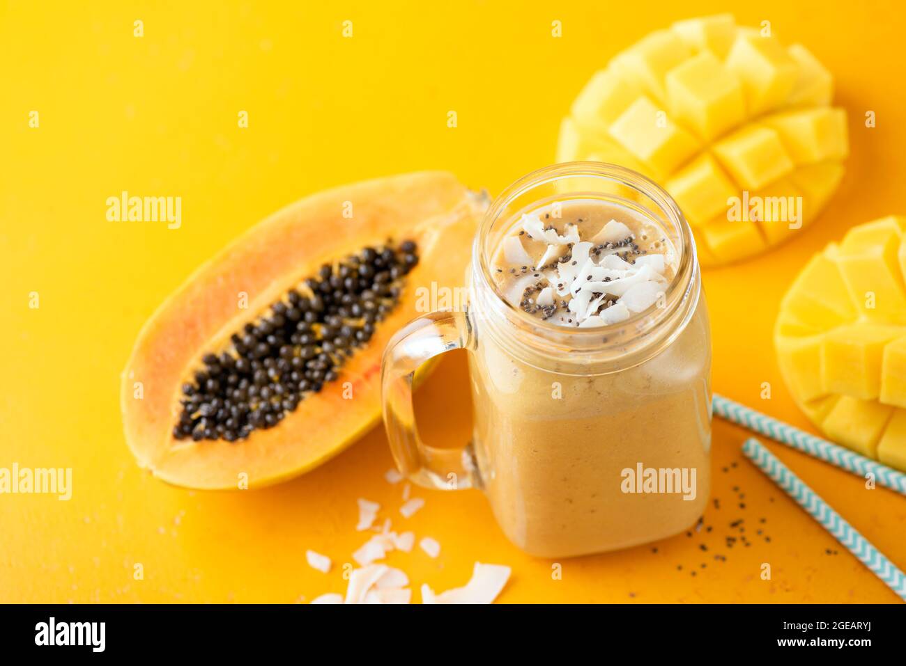 Frullato di papaya tropicale in vaso di vetro su sfondo giallo. Frullato di frutta vegana Foto Stock