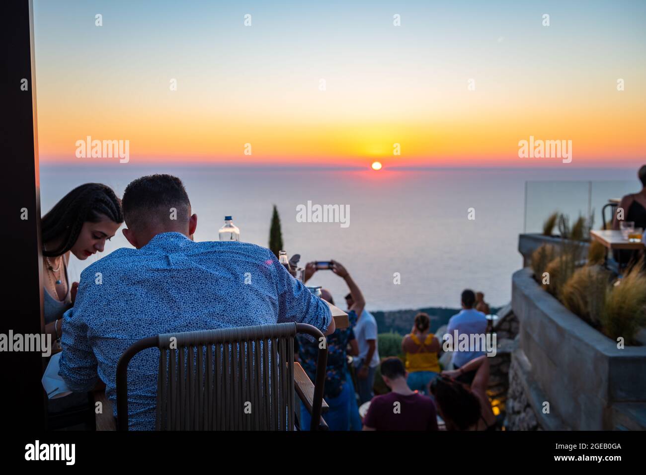 Isola di Lefkada. Grecia- 08.07.2021: Persone e turisti che godono di una cucina raffinata in un ristorante in cima a una collina con vista incredibile tramonto. Foto Stock
