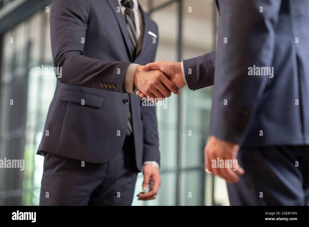 Uomini d’affari cinesi di successo che scuotono le mani in ufficio Foto Stock