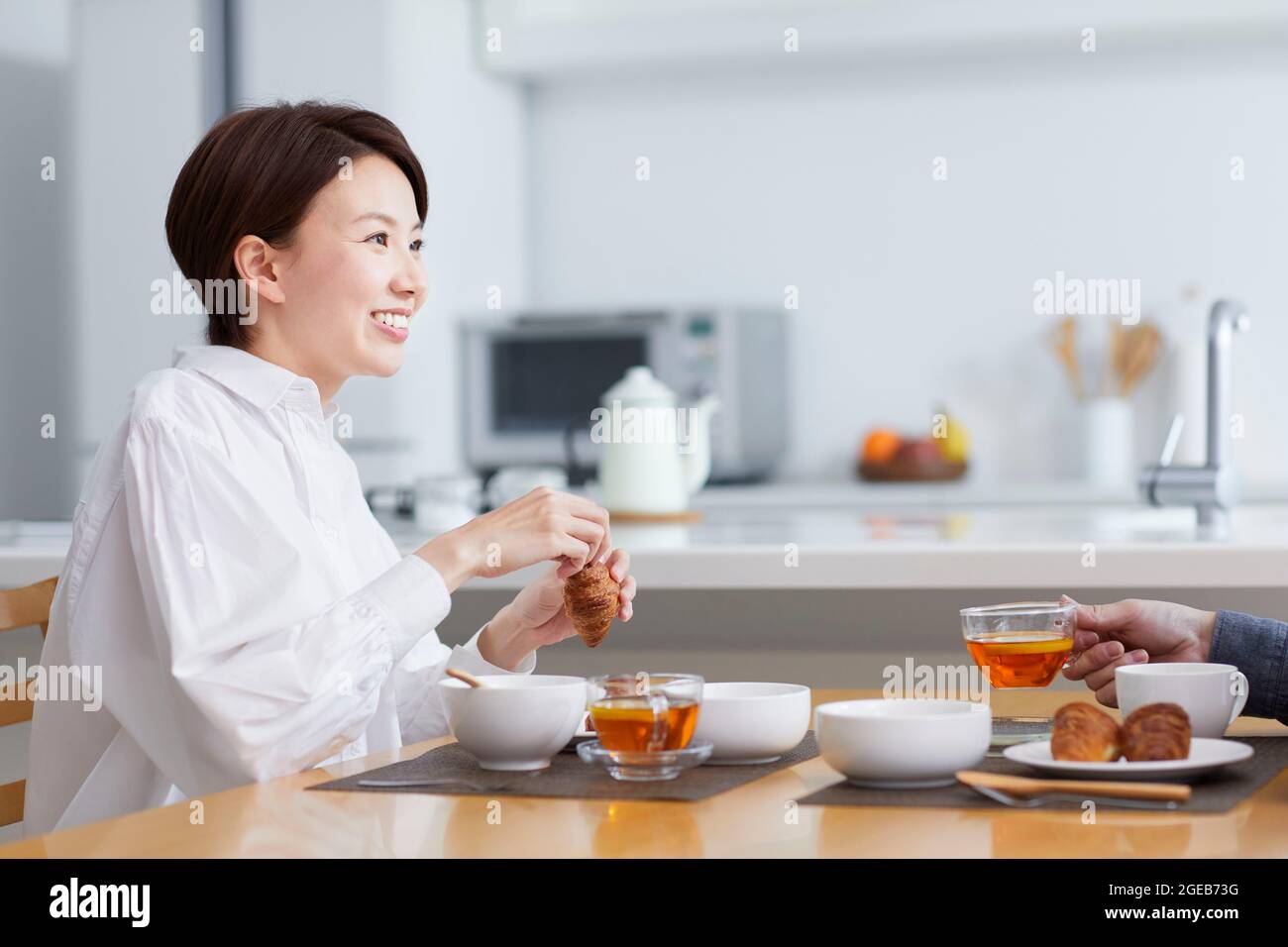 Donna giapponese che mangia a casa Foto Stock