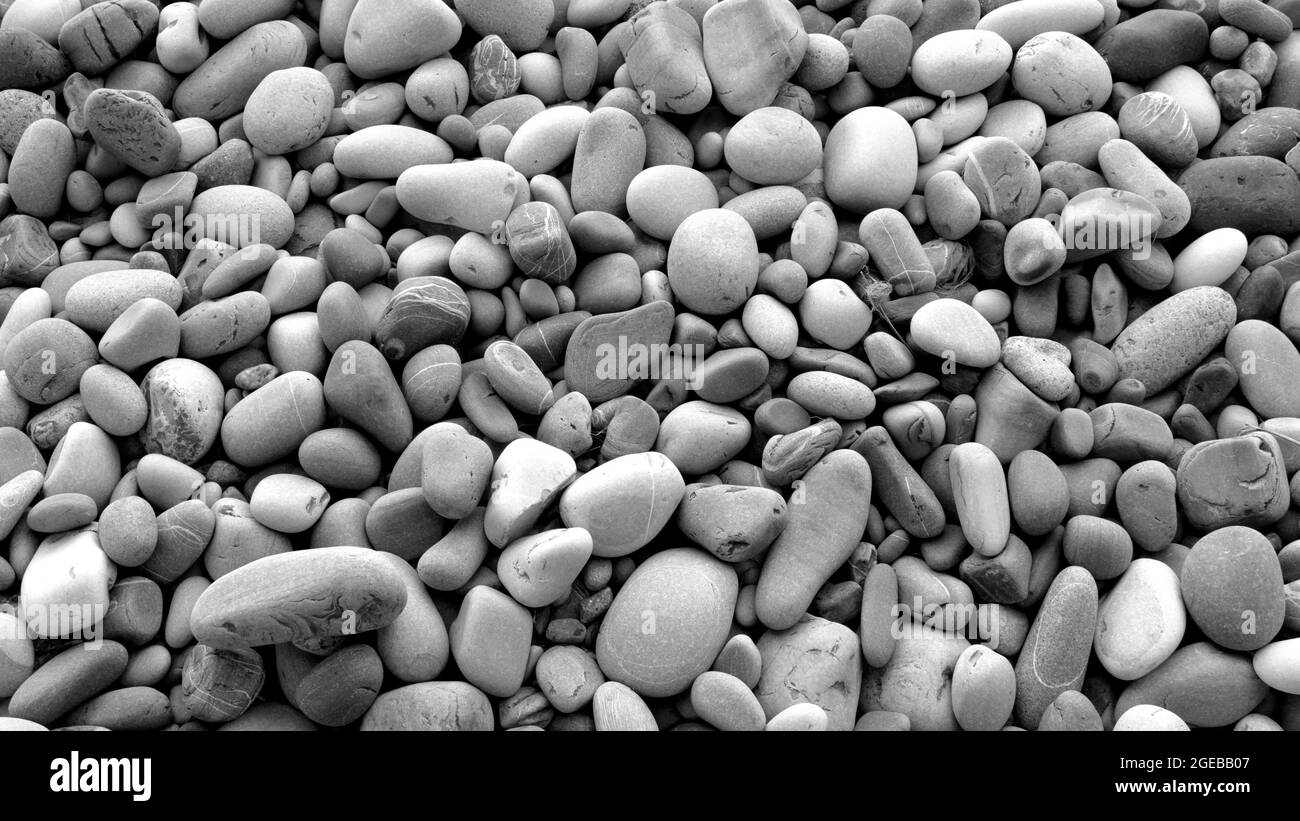 Sfondo di pietre di mare con piccoli ciottoli o pietra in giardino o in mare o su una spiaggia. Vista ravvicinata delle pietre di ciottoli levigate e arrotondate. Foto Stock