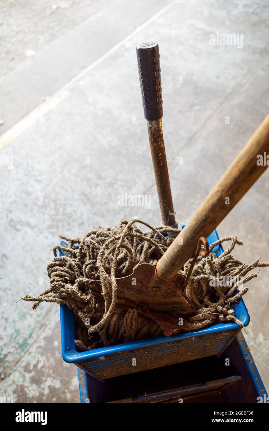 spazzolone da pavimento vecchio con manico in legno e secchio per spazzolone blu Foto Stock