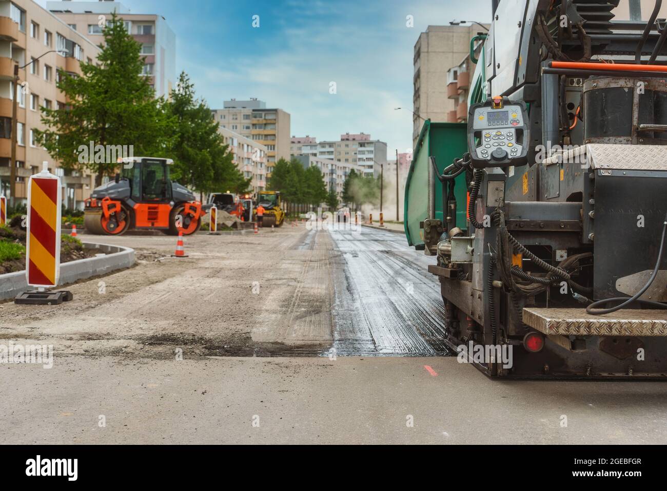 Macchina per pavimentazione stradale in funzione sulla strada. Foto Stock