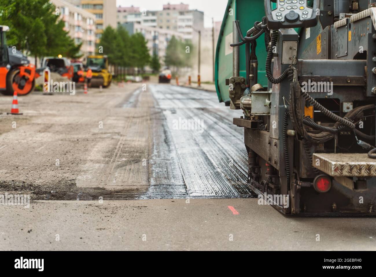 Macchina per pavimentazione stradale in funzione sulla strada. Foto Stock