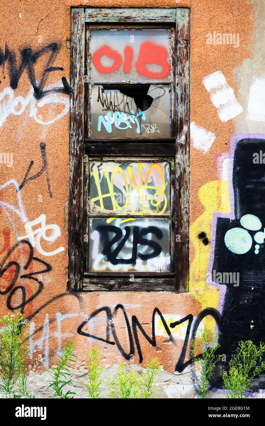 Vecchia cornice finestra decadente e parete sfaldante con graffiti Foto Stock