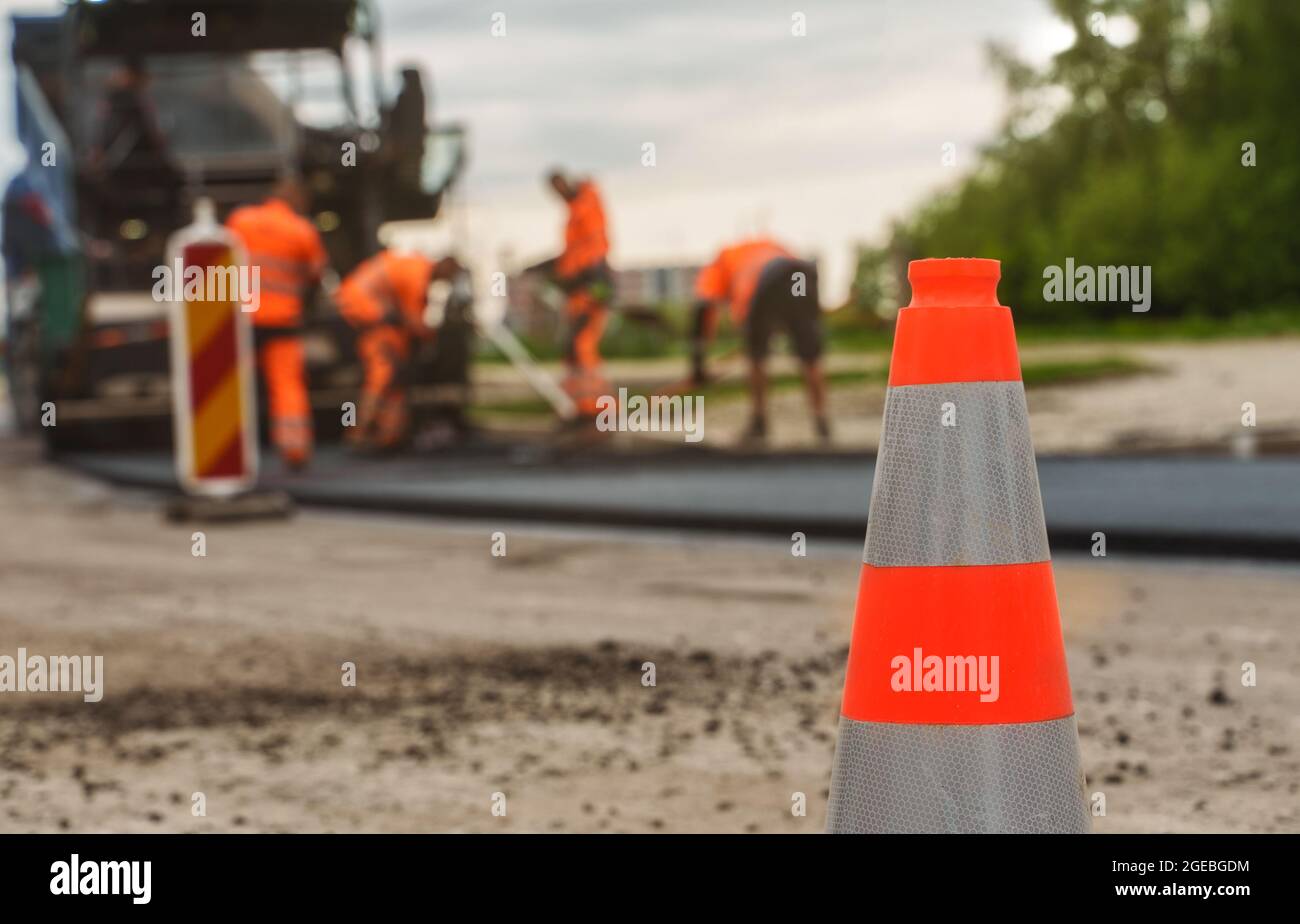 Macchina per pavimentazione stradale in funzione sulla strada. Foto Stock