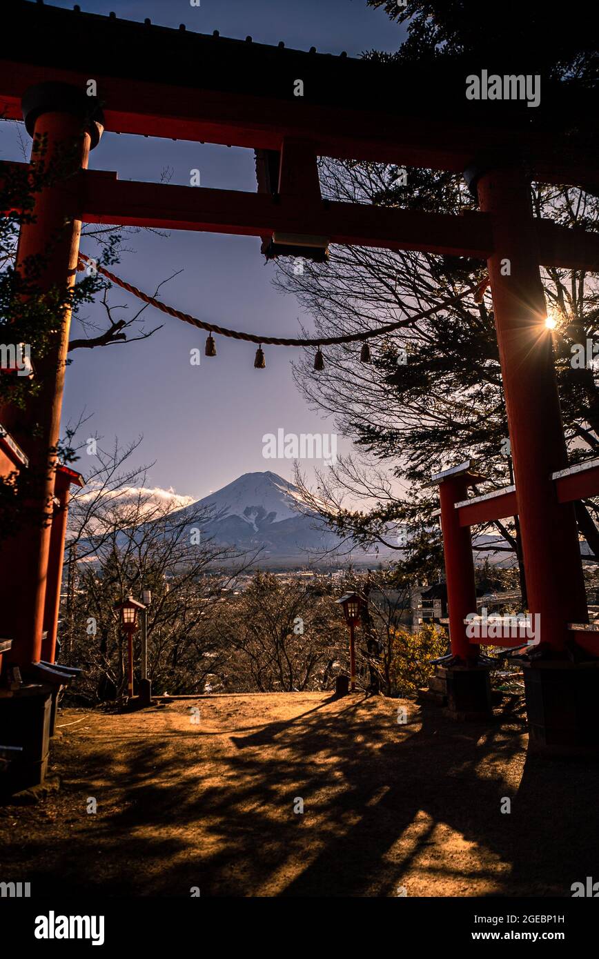 Un tradizionale torii rosso e la montagna Fuji con la copertura della neve al tramonto, splendido luogo di viaggio punto di riferimento. Stagioni invernali paesaggio giapponese con un Tor Foto Stock