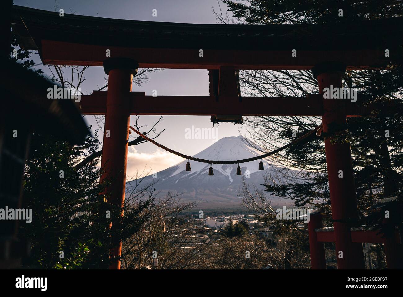 Tradizionali torii rossi e Fuji montagna con neve coperta al tramonto, bellissimo punto di riferimento luogo di viaggio. Stagioni invernali paesaggio giapponese con una porta Tori Foto Stock