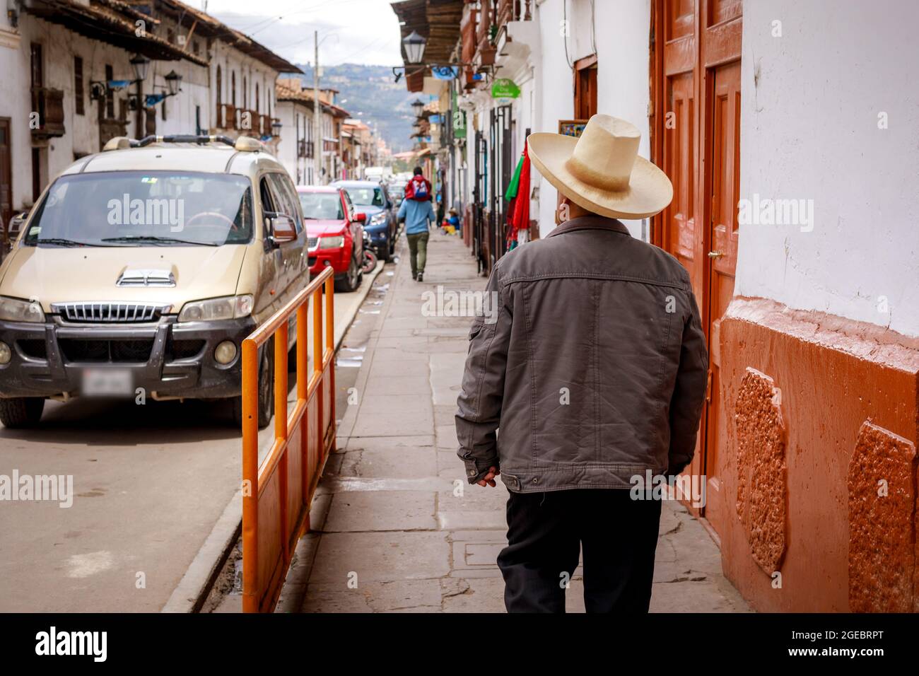 Un uomo peruviano che indossa un cappello tradizionale che cammina lungo la  strada nel centro della città di Cajamarca in Perù Foto stock - Alamy