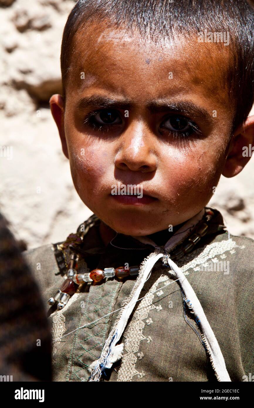 BASE DI PATTUGLIA FULOD, provincia di Helmand, Repubblica Islamica dell'Afghanistan - Seaman Orlando C. Farase, corpsman del Team Advisor 4 annesso alla Società C, 1° Battaglione, 5° reggimento marino, bende la mano di un bambino mentre è in pattuglia a Sangin, Afghanistan, maggio 11. I soldati dell'esercito nazionale afghano del 2° Tolay, il 2° Kandak, guidarono la pattuglia di presenza attraverso Sangin e furono accompagnati da consulenti marini per la squadra che era strettamente lì per osservare i soldati dell'ANA e offrire un feedback. Farase, 22 anni, è di Pensacola, Fla. Foto Stock