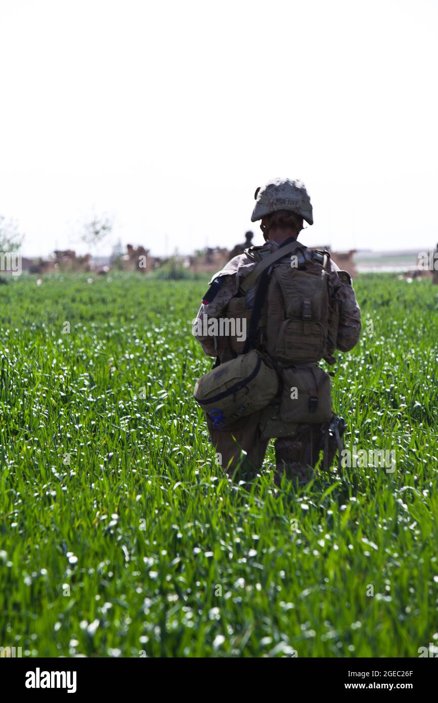 BASE DI PATTUGLIA FULOD, provincia di Helmand, Repubblica Islamica dell'Afghanistan - Seaman Orlando C. Farase, corpsman del Team Advisor 4 annesso alla Società C, 1° Battaglione, 5° reggimento marino, bende la mano di un bambino mentre è in pattuglia a Sangin, Afghanistan, maggio 11. I soldati dell'esercito nazionale afghano del 2° Tolay, il 2° Kandak, guidarono la pattuglia di presenza attraverso Sangin e furono accompagnati da consulenti marini per la squadra che era strettamente lì per osservare i soldati dell'ANA e offrire un feedback. Farase, 22 anni, è di Pensacola, Fla. Foto Stock