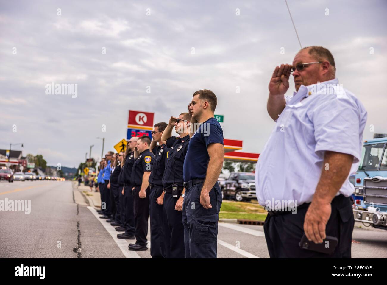 Bloomington, Stati Uniti. 18 agosto 2021. I vigili del fuoco rendono onore durante la processione funeraria del paramedico caduto Brandon Staley su W. Morgan Street a Spencer, Indiana.Staley morì per un attacco di cuore mentre lavorava come paramedico per Owen County EMS (Emergency Medical Services). Staley aveva appena risposto a un incidente stradale e si trovava in un'ambulanza con i sopravvissuti agli incidenti che li aiutavano durante il viaggio verso un ospedale quando egli stesso si ammalò. Credit: SOPA Images Limited/Alamy Live News Foto Stock