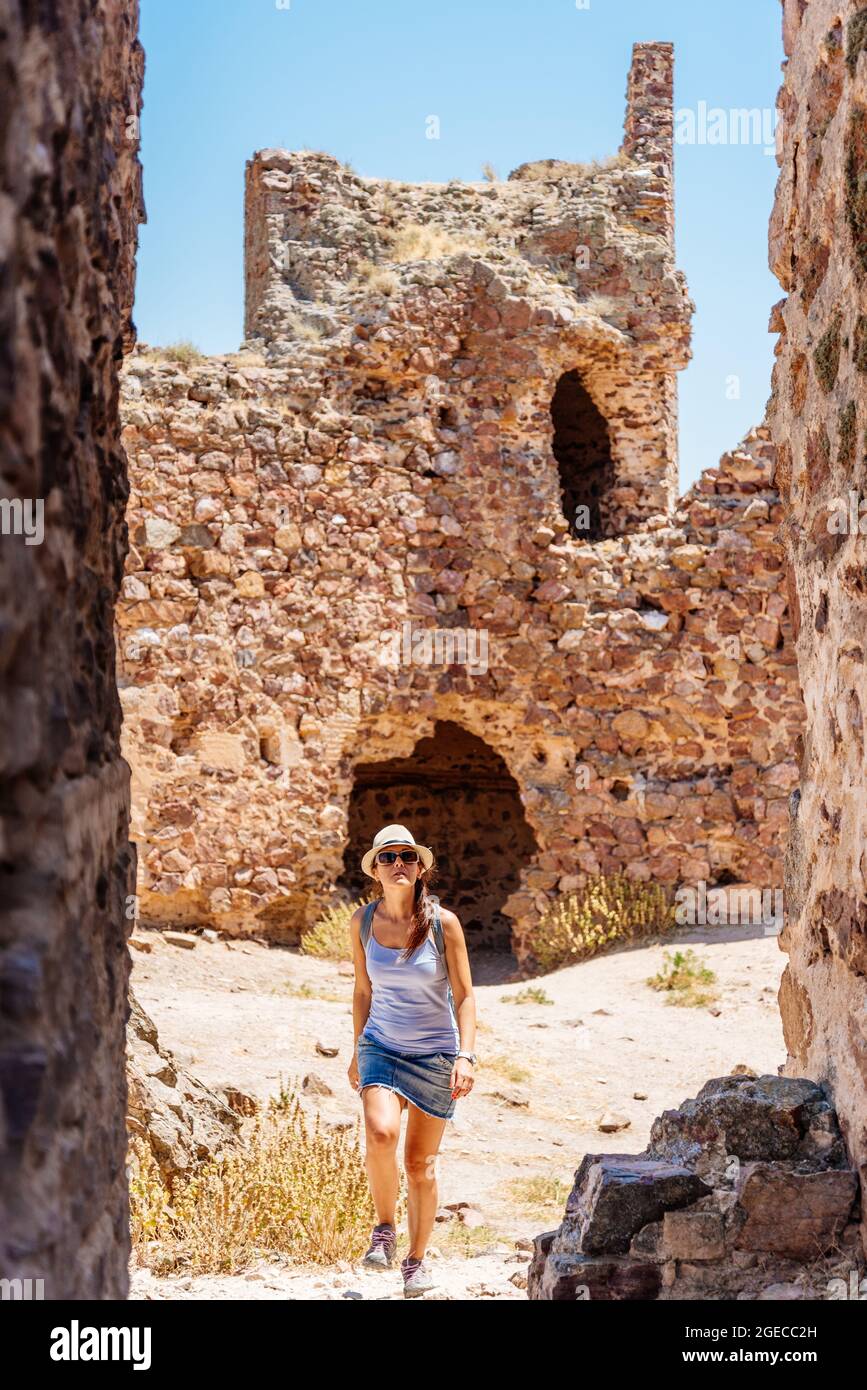 Donna che visita un castello di pietra restaurato in una giornata di sole Foto Stock