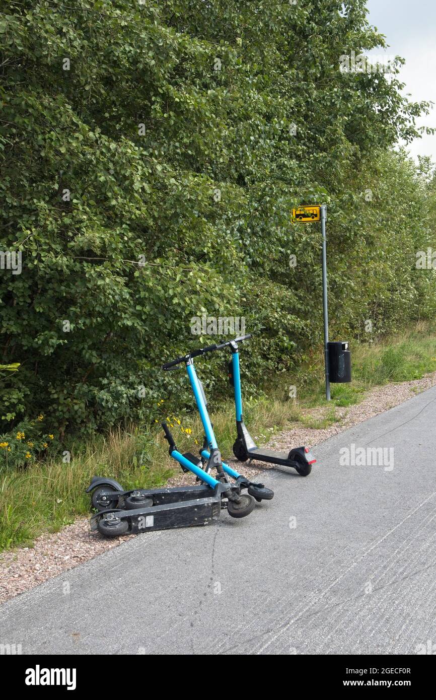 Noleggio scooter elettrici parcheggiati presso una fermata dell'autobus Foto Stock