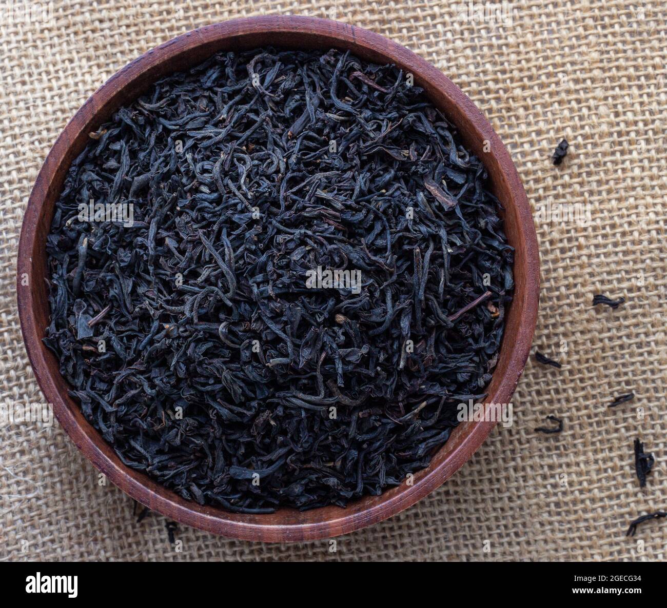 Foglie di tè Assam essiccato in una ciotola di legno Foto Stock