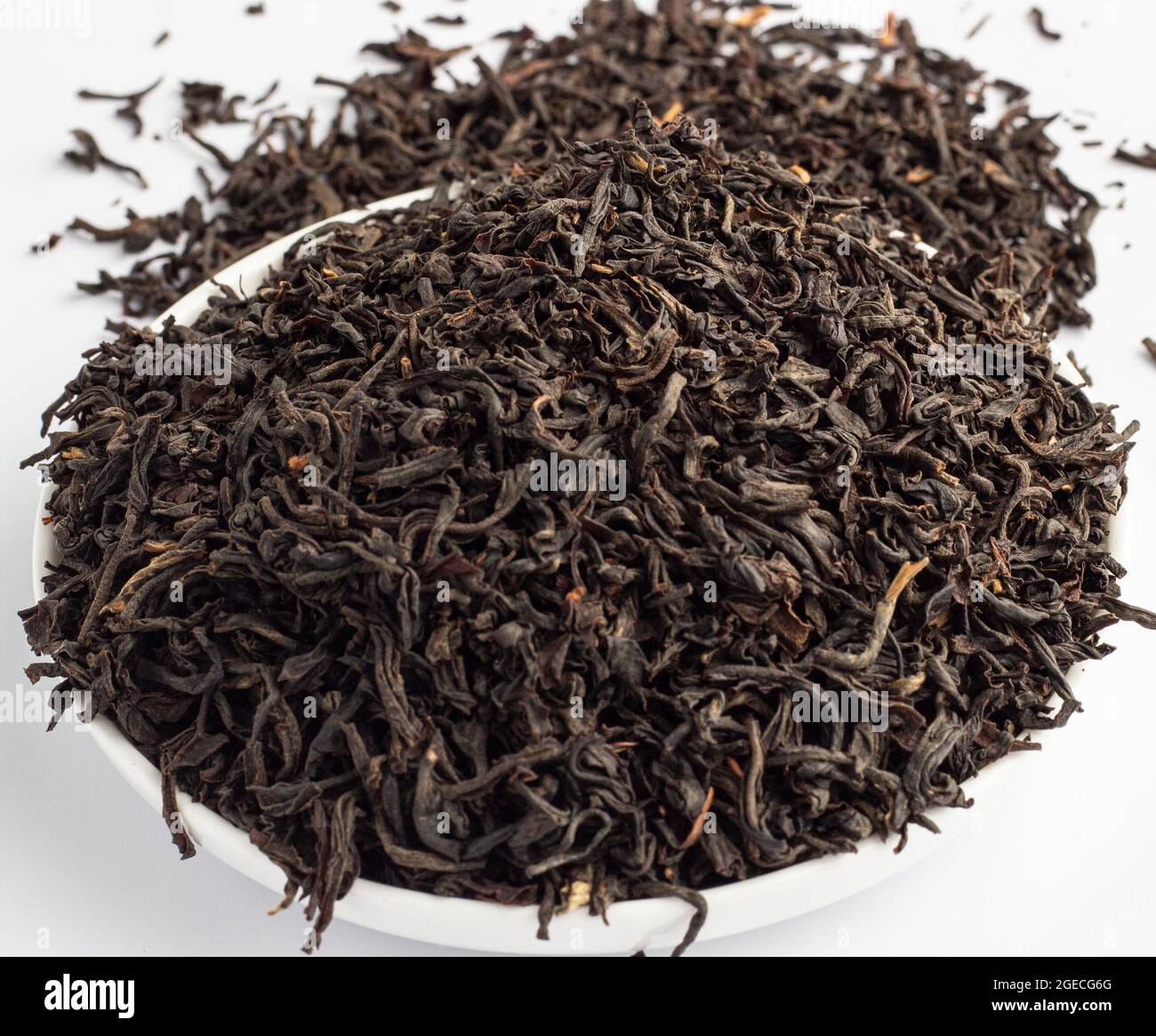 Foglie di tè Assam essiccato su sfondo bianco Foto Stock