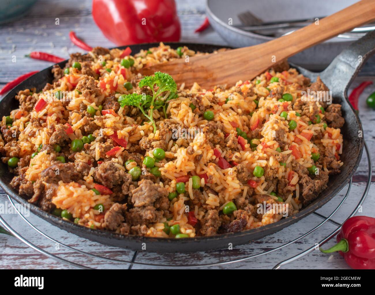 Piatto di carne tritato serbo con riso djuvec preparato con paprika, piselli verdi e ajvar servito caldo su un tavolo da cucina Foto Stock