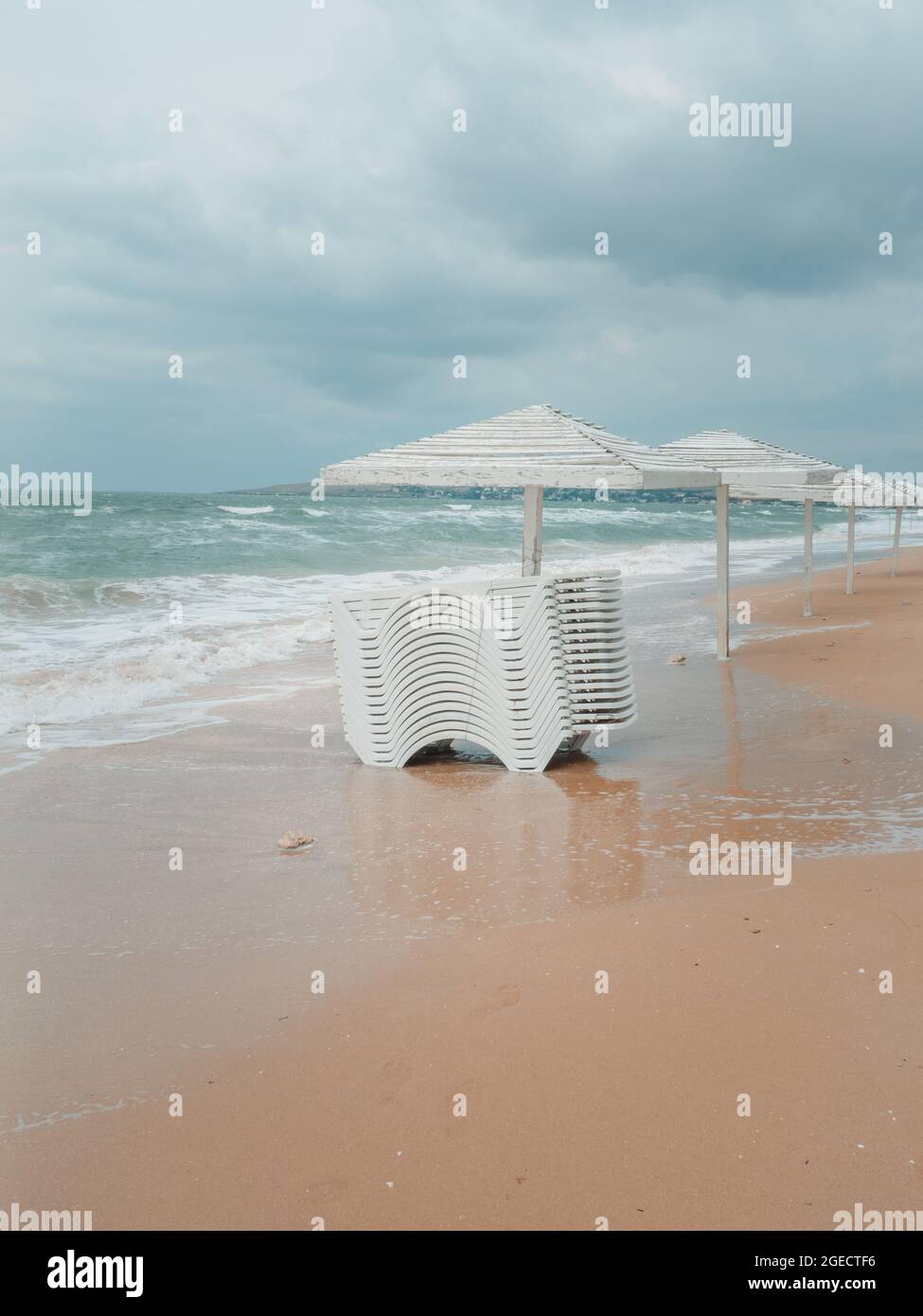 Ombrelloni bianchi sulla sabbia. Tempesta. Foto Stock