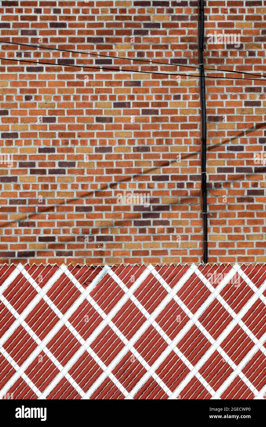 Una foto astratta di forme, colori, una recinzione, muro e fili in Queens, New York. Foto Stock