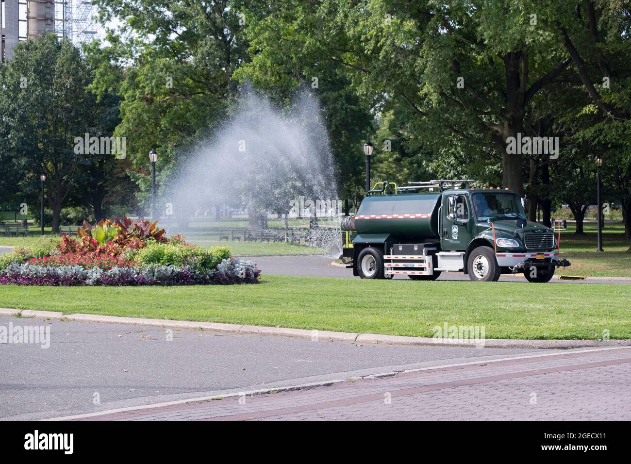 Un camion del Dipartimento dei Parchi di New York City con un tubo potente acque colorate piante . A Flushing Meadows corona Park a New York City. Foto Stock