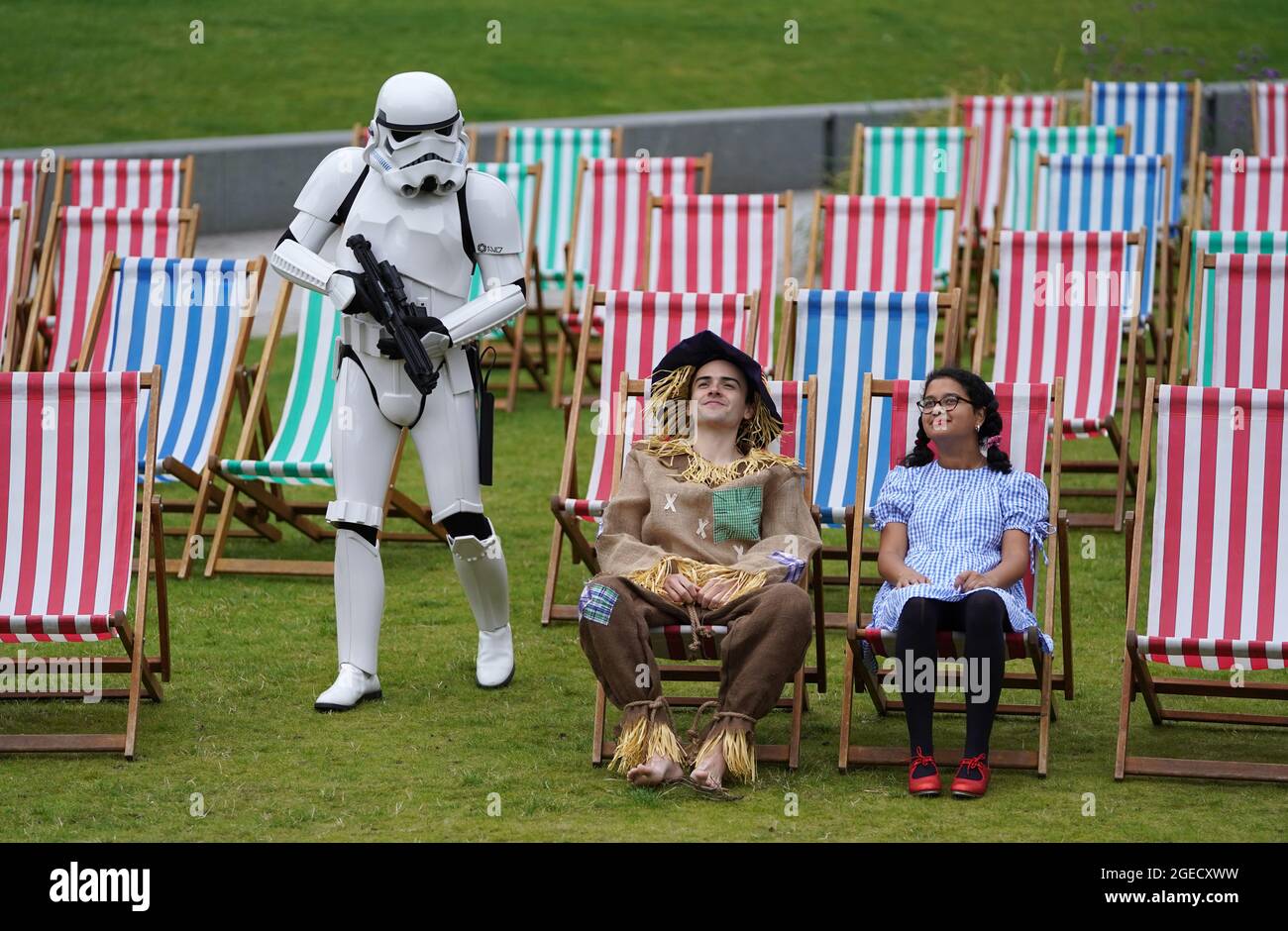 Aditi Jehangir come Dorothy e Ewan Shand come Scarecrow insieme a Brian McDavid come un Stormtrooper che rappresenta il Mago di Oz e Star Wars due dei film popolari schierati per il Film Fest di quest'anno in città mentre camminano tra le sedie a sdraio in un'area di osservazione all'aperto a St Andrew Square, come parte dell'Edinburgh International Film Festival. Data immagine: Giovedì 19 agosto 2021. Foto Stock