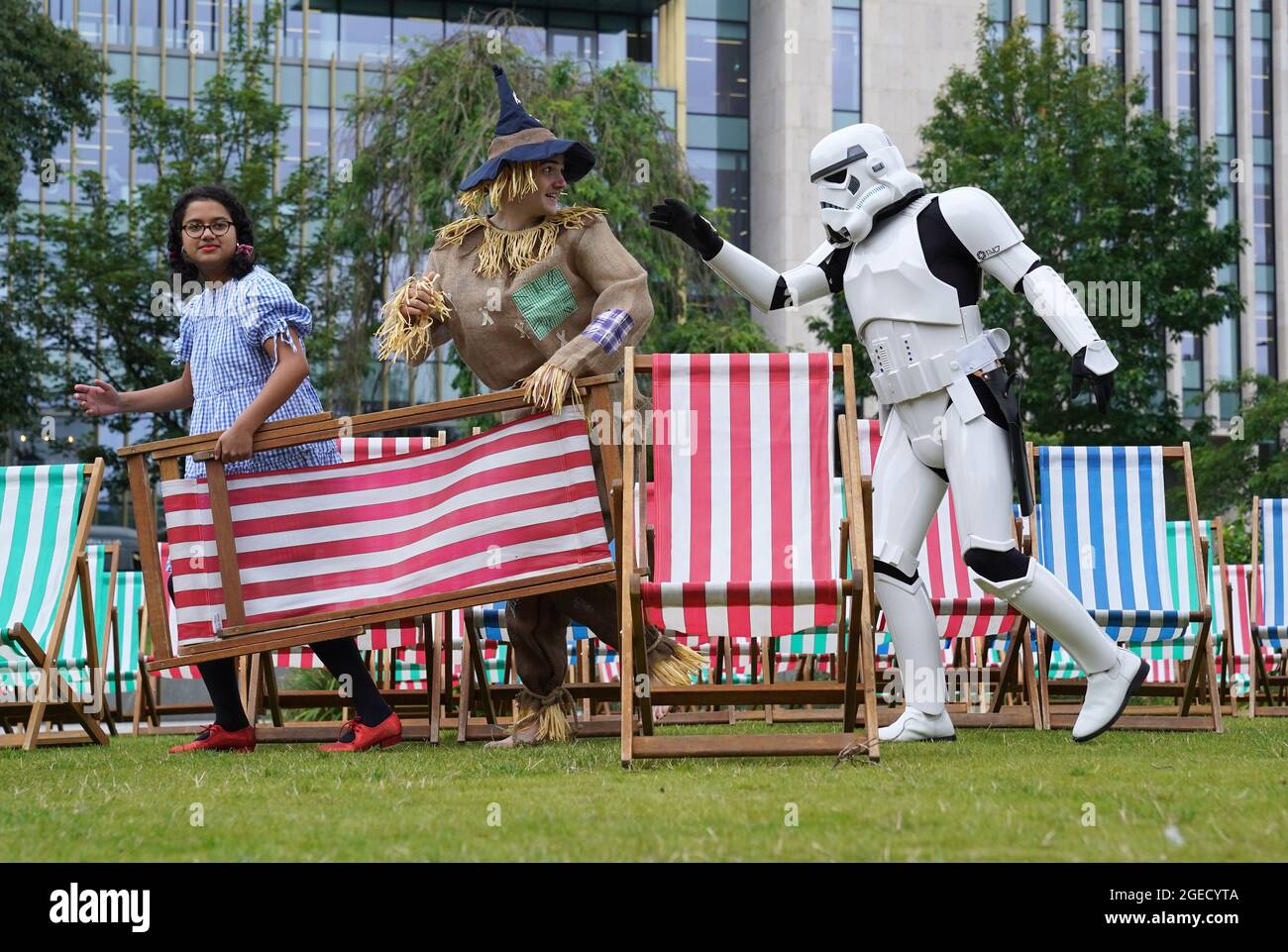 Aditi Jehangir come Dorothy e Ewan Shand come Scarecrow insieme a Brian McDavid come un Stormtrooper che rappresenta il Mago di Oz e Star Wars due dei film popolari schierati per il Film Fest di quest'anno in città mentre camminano tra le sedie a sdraio in un'area di osservazione all'aperto a St Andrew Square, come parte dell'Edinburgh International Film Festival. Data immagine: Giovedì 19 agosto 2021. Foto Stock