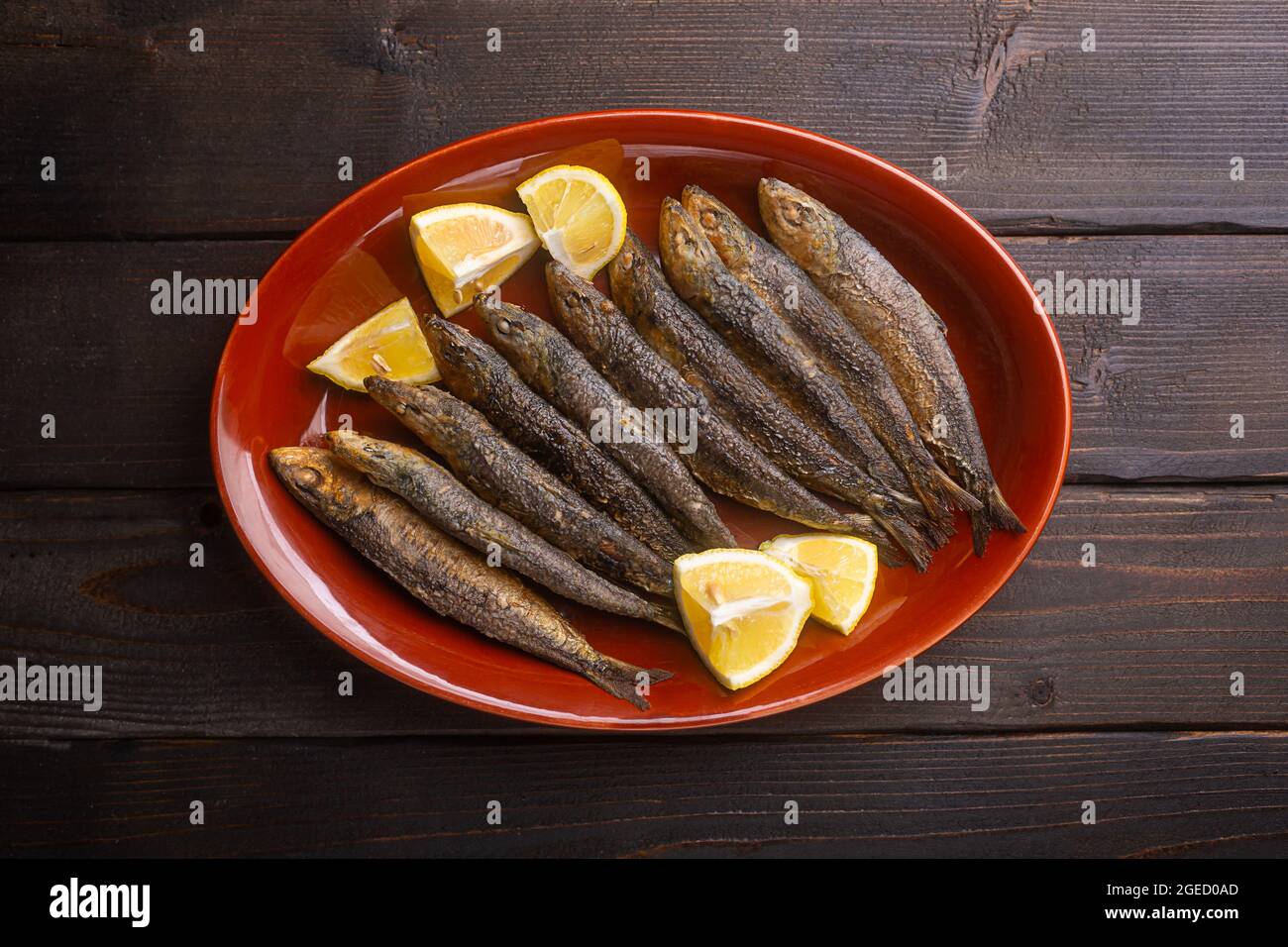 Le sardine preparate di fresco fanno parte della cucina Mediterranea, vista dall'alto, sfondo in legno Foto Stock