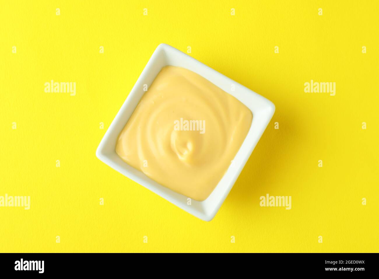 Ciotola con salsa di formaggio su fondo giallo Foto Stock