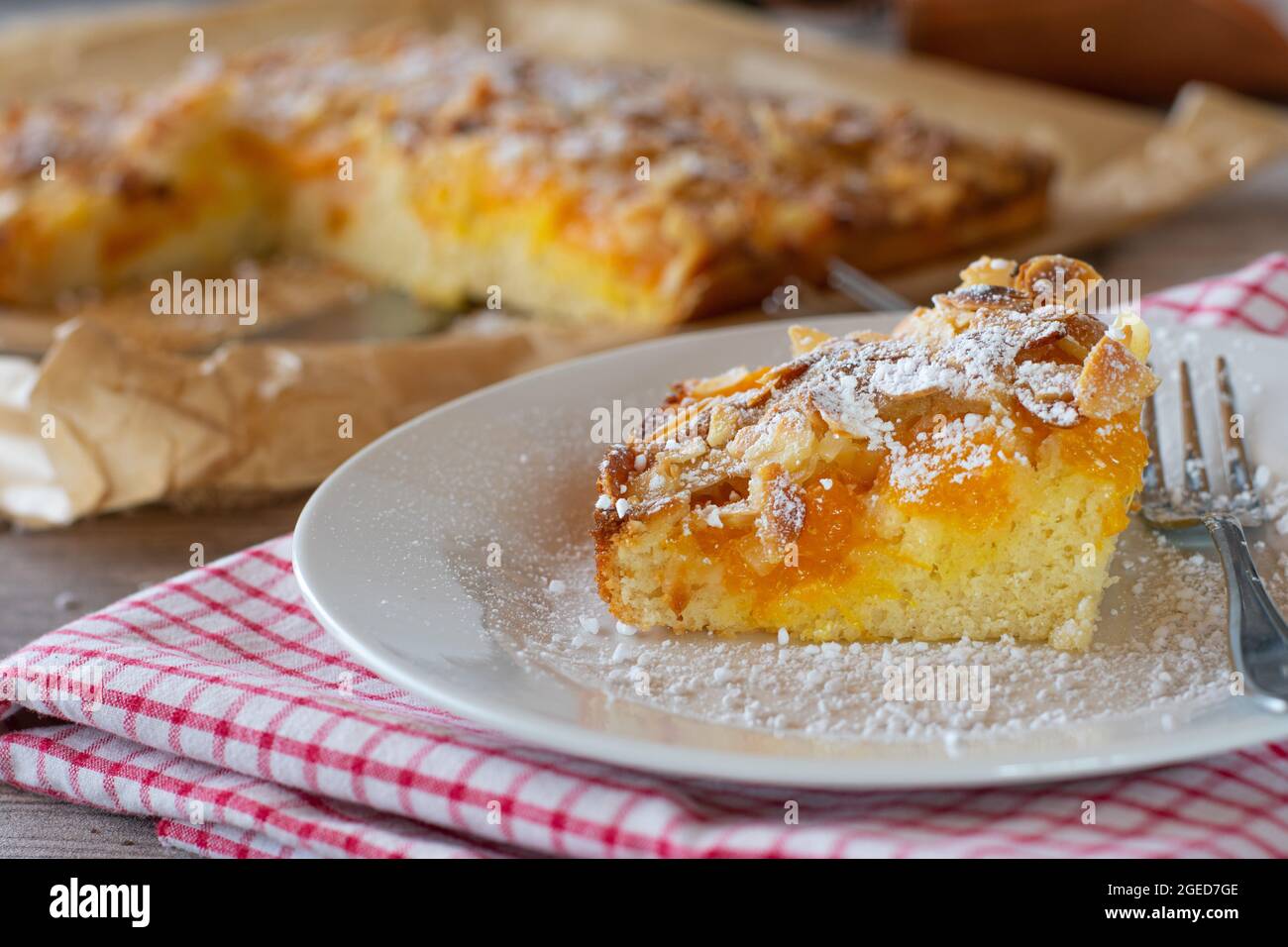 Un pezzo di torta con mandorle e frutta su un piatto Foto Stock