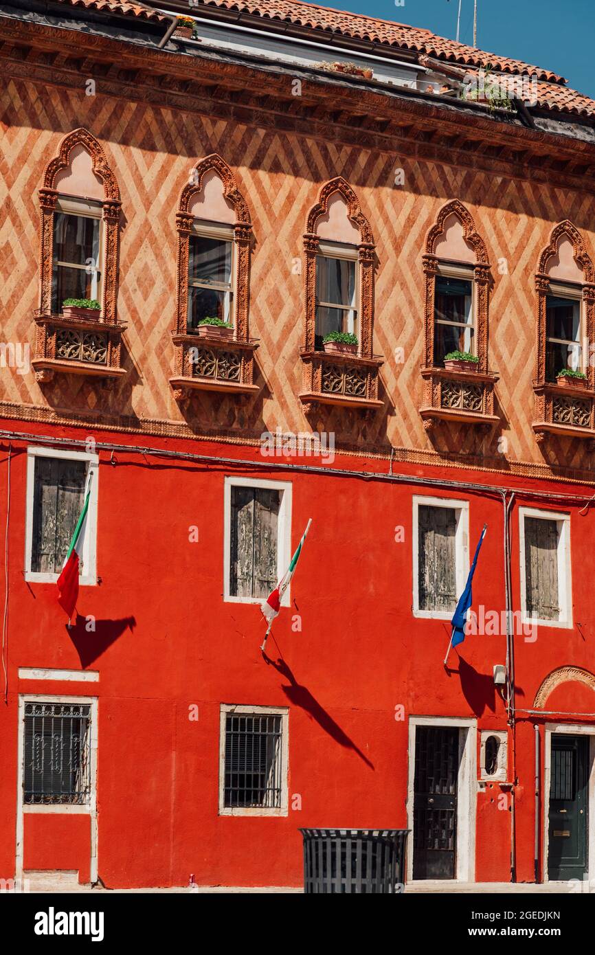 Foto verticale di una facciata di un edificio con bandiere a Venezia Foto Stock