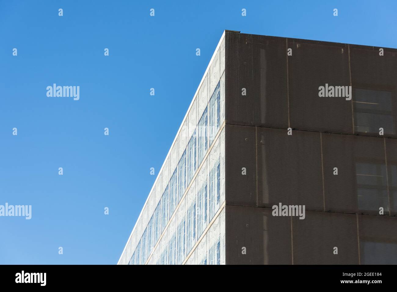 L'angolo dell'edificio, il lato luminoso e il buio contro il cielo blu Foto Stock