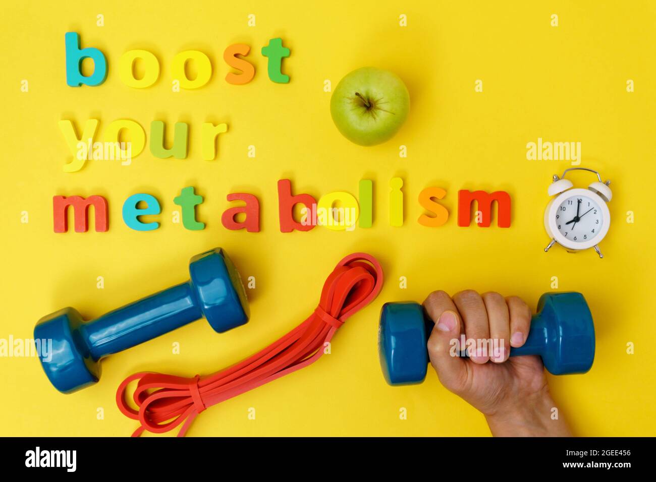 Aumenta il metabolismo, lo sport e il dumbbell. Vista dall'alto. Sfondo giallo Foto Stock