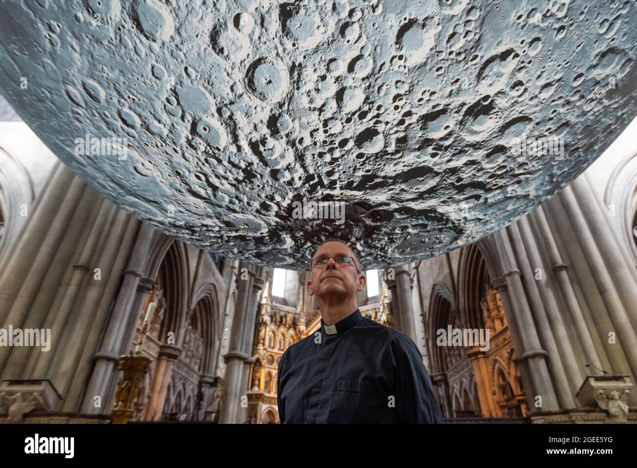 Londra, Regno Unito. 19 agosto 2021. Il Vicario James Heard presenta con Luke Jerram ‘s Museum of the Moon, un'opera d'arte del diametro di 7 m che presenta immagini dettagliate della superficie lunare della NASA. Con una scala approssimativa di 1:500,000, ogni centimetro della sfera illuminata internamente rappresenta 5 km della superficie lunare. Le opere d'arte itineranti sono esposte fino al 30 agosto presso la chiesa di San Giovanni Battista vicino a Shepherd's Bush e fanno parte del Kensington and Chelsea Festival di quest'anno. Credit: Stephen Chung / Alamy Live News Foto Stock