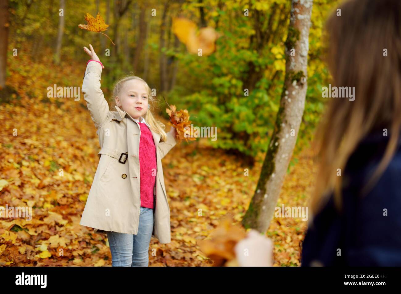 Due simpatici giovani suore divertirsi sulla bellissima giornata autunnale. Felici i bambini che giocano nel parco d'autunno. Bambini raccolta giallo caduta delle foglie. Autunno activitie Foto Stock
