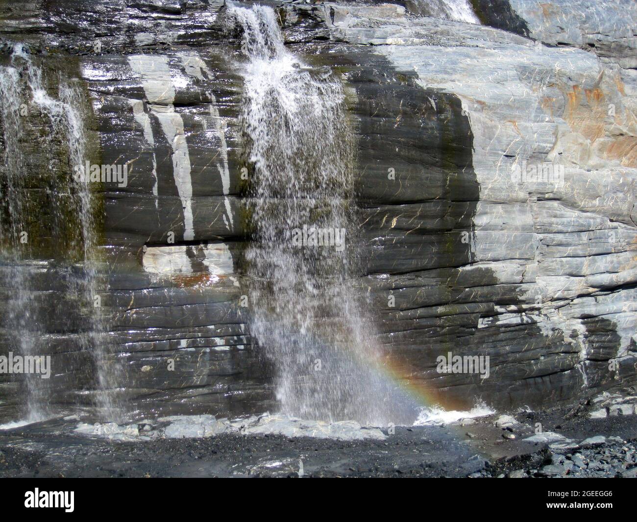 L'arcobaleno piccolo si forma nelle molte piccole cascate del Ghiacciaio di Worthington in Alaska. Foto Stock