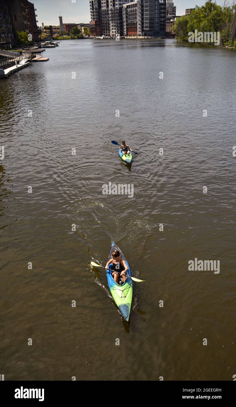 Vista aerea donne pagaiare kayak per l'esercizio e il divertimento all'aperto sulle acque color marrone del fiume Milwaukee nel centro di Milwaukee, WISCONSIN, Stati Uniti Foto Stock