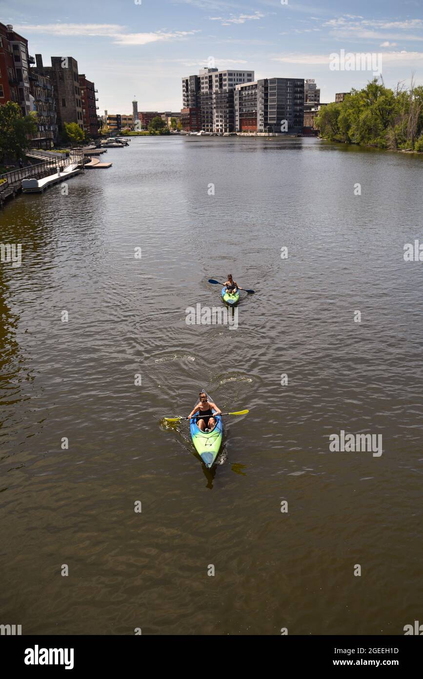 Vista aerea donne pagaiare kayak per l'esercizio e il divertimento all'aperto sulle acque color marrone del fiume Milwaukee nel centro di Milwaukee, WISCONSIN, Stati Uniti Foto Stock